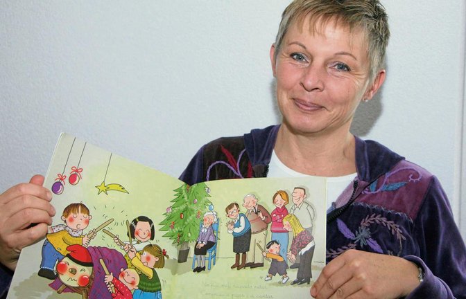 Angelika del Chin aus Oberriexingen zeigt ein Kinderbuch, in dem Weihnachtsbräuche aus Katalonien dargestellt sind.  Foto: Gergen