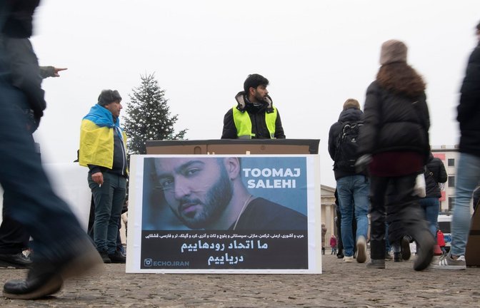 Protestaktion gegen Irans Staatsführung auf dem Pariser Platz in Berlin. Auf dem Plakat ist der Rapper Salehi zu sehen.<span class='image-autor'>Foto: Paul Zinken/dpa</span>