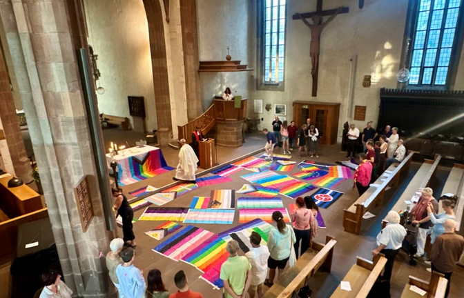 Bunter CSD-Gottesdienst in der Leonhardskirche: vor dem Altar sind Fahnen der LGBTQ-Community ausgebreitet.<span class='image-autor'>Jan Sellner</span>
