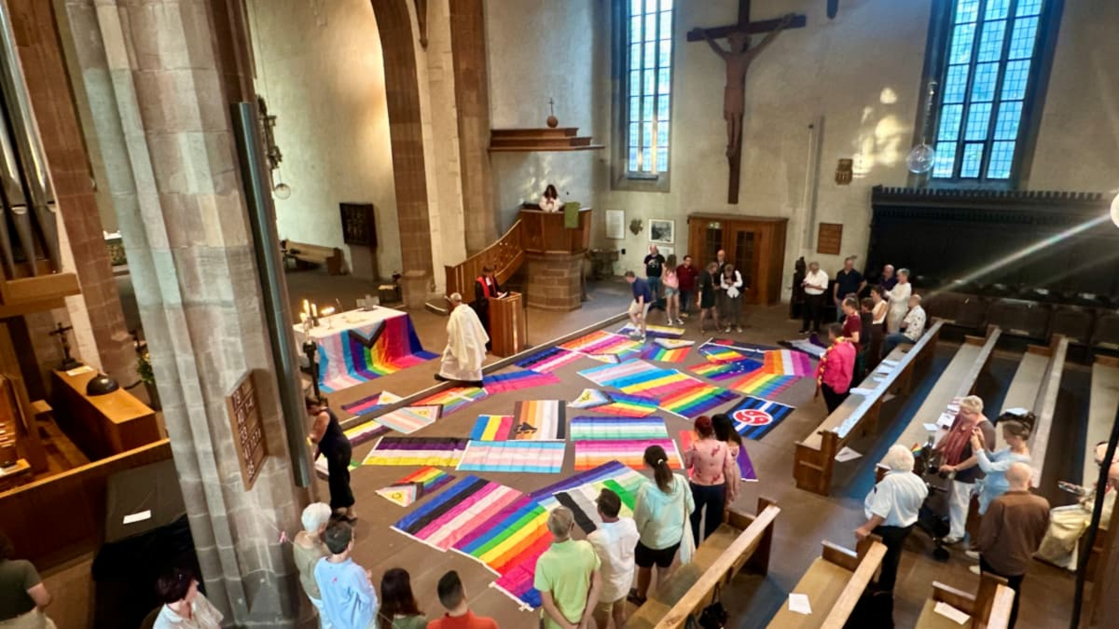 Bunter CSD-Gottesdienst in der Leonhardskirche: vor dem Altar sind Fahnen der LGBTQ-Community ausgebreitet.Jan Sellner Bunter CSD-Gottesdienst in der Leonhardskirche: vor dem Altar sind Fahnen der LGBTQ-Community ausgebreitet.Jan Sellner