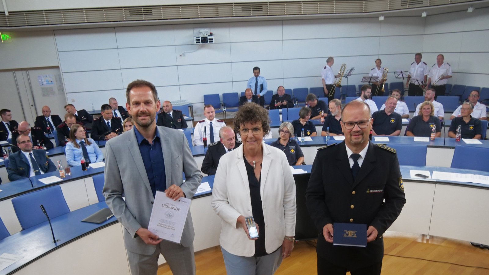 „Es war gigantisch. Sie haben Großartiges geleistet“: Landrat Bastian Rosenau (links), Regierungspräsidentin Sylvia M. Felder und Kreisbrandmeister Carsten Sorg überreichen den Einsatzkräften die Fluthilfemedaille des Landes Rheinland-Pfalz.  Foto: Friedrich