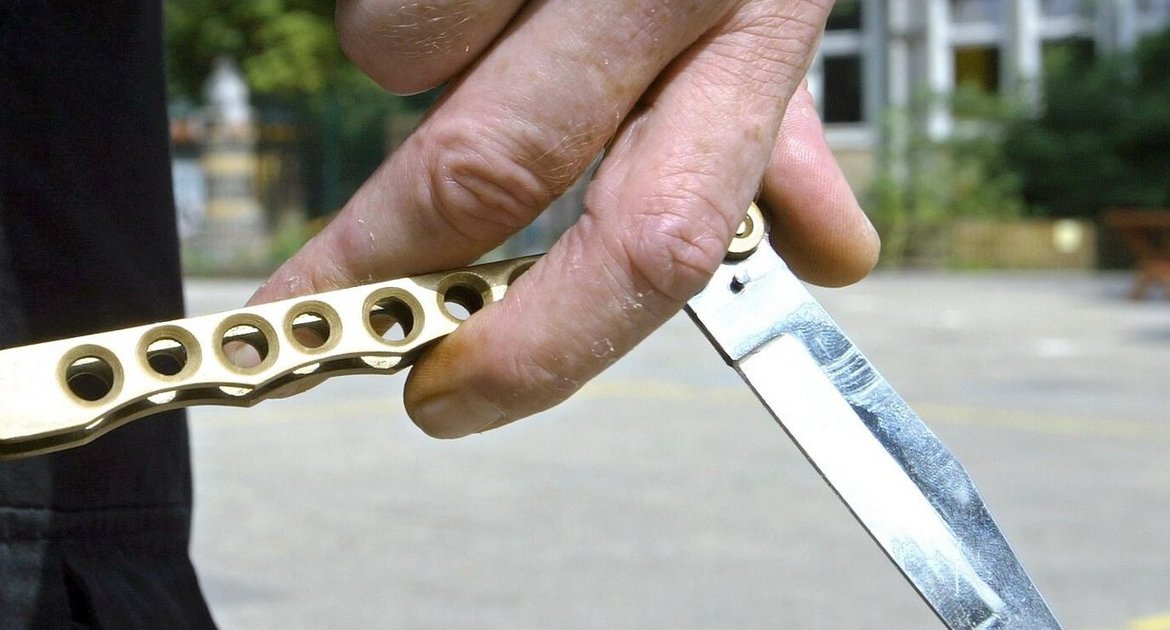 Ein Junge hält auf dem Hof einer Schule ein so genanntes Butterflymesser in seiner Hand (gestellte Szene vom 13.08.2003, Illustration zum Thema Schulgewalt). Lehrer und Polizei müssen nach Ansicht der Deutschen Polizeigewerkschaft (DPolG) rechtzeitig gemeinsame Strategien gegen Gewalt an Schulen entwickeln. Wenn die Polizei komme, dann sei im Regelfall das Kind schon in den Brunnen gefallen. Man müsse früher miteinander reden, sagte der Gewerkschafts- Vorsitzende Speck am Freitag (31.03.2006) in einem dpa-Gespräch. Foto: Ingo Wagner (zu dpa 4196 vom 31.03.2006) +++ dpa-Bildfunk +++ 