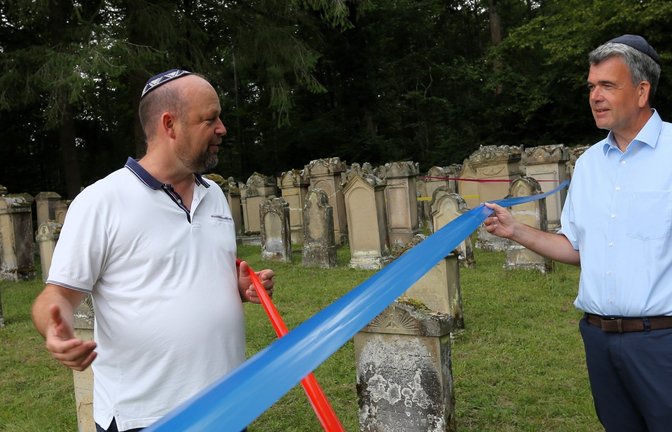 Alexander Fleig (rechts) und Michael Volz halten zwei der Lebenslinien, die Gräber auf dem jüdischen Friedhof in Freudental verbinden. <span class='image-autor'>Foto: Küppers</span>