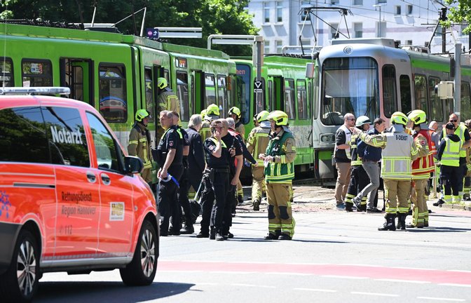 Einsatzkräfte von Polizei und Feuerwehr stehen nach einem Unfall neben zwei Stadtbahnen.<span class='image-autor'>Foto: Julian Stratenschulte/dpa</span>