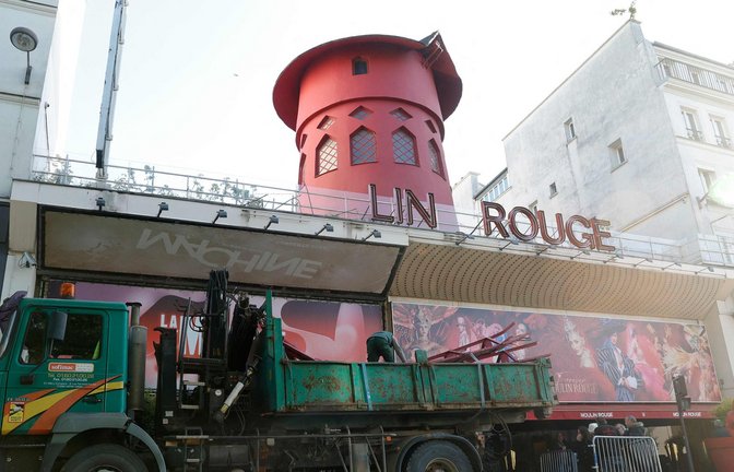 Arbeiter sichern den Bereich vor dem Kabarett, nachdem die Flügel des Windrads des "Moulin Rouge" in der Nacht abgestürzt sind.<span class='image-autor'>Foto: Geoffroy Van Der Hasselt/AFP/dpa</span>