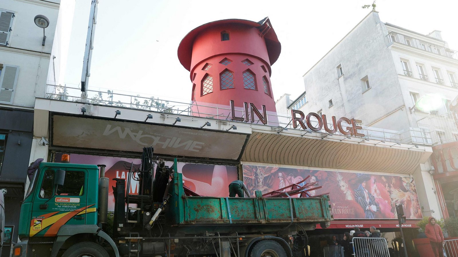 Arbeiter sichern den Bereich vor dem Kabarett, nachdem die Flügel des Windrads des "Moulin Rouge" in der Nacht abgestürzt sind.Foto: Geoffroy Van Der Hasselt/AFP/dpa