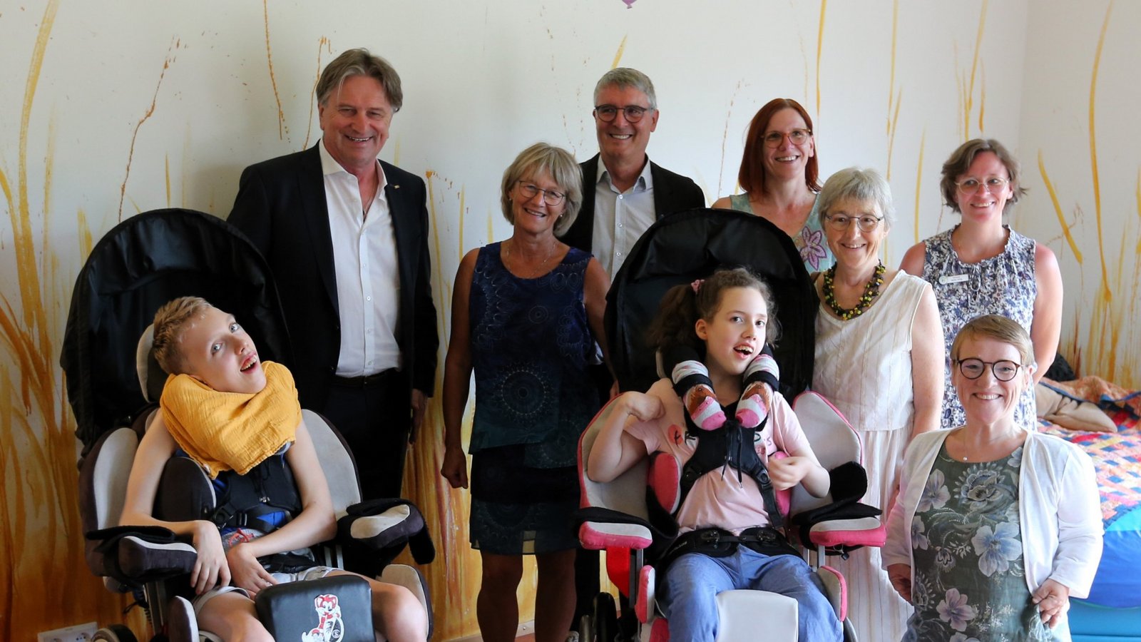 Besuch der Familienherberge Lebensweg in Schützingen: Sozialminister Manfred Lucha (hinten links) informiert sich bei Gründerin und Geschäftsführerin Karin Ecksten (rechts daneben) über aktuelle Probleme. Die Beauftragte für die Belange von Menschen mit Behinderung, Simone Fischer (rechts vorne) freut sich, dass es inzwischen ein Recht auf Teilhabe gibt. Marius (vorne links) und Emma sind Gäste der ersten Stunde. Foto: Küppers