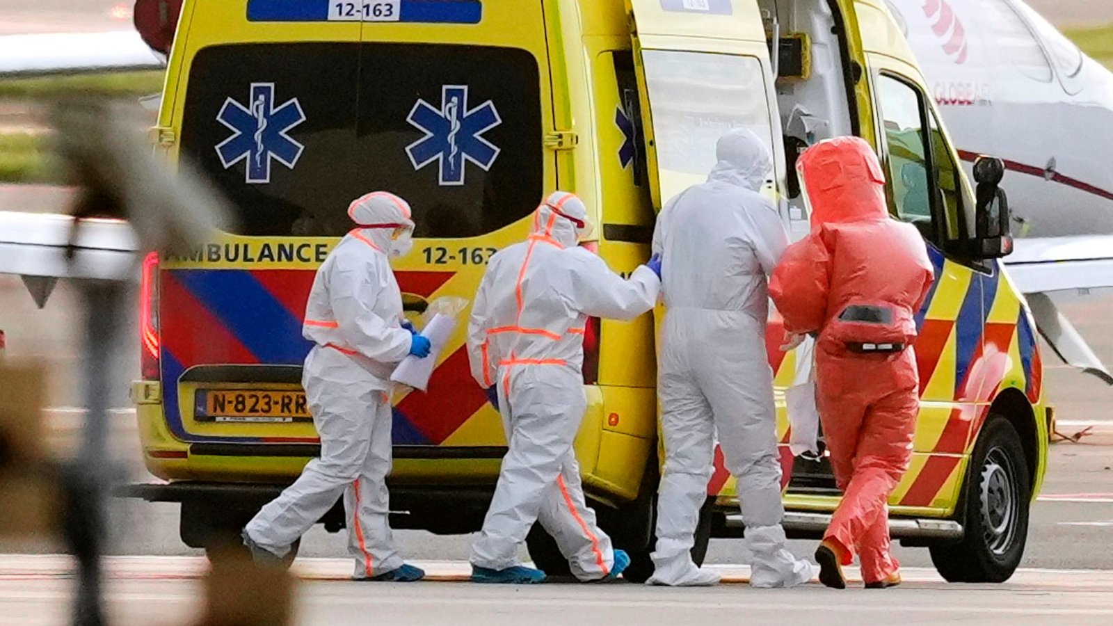 Sanitäter begleiteten eine Person mit Verdacht auf eine Hantavirus-Infektion auf dem Amsterdamer Flughafen zu einem Krankenwagen.Foto: Peter Dejong/AP/dpa