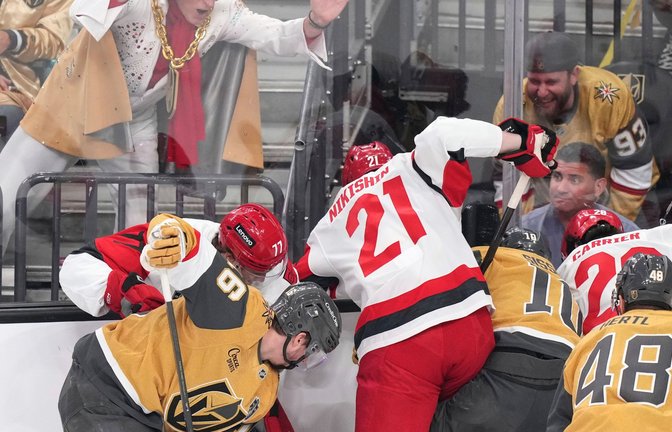 Ein Elvis-Imitator schlägt auf die Scheibe, während die Spieler um den Puck kämpfen.<span class='image-autor'>Foto: Candice Ward/AP/dpa</span>