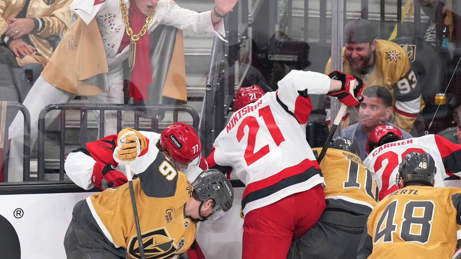 Ein Elvis-Imitator schlägt auf die Scheibe, während die Spieler um den Puck kämpfen.Foto: Candice Ward/AP/dpa