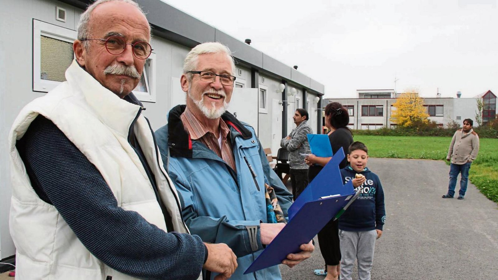 Klaus Oßwald (links) im Gespräch mit Douglas Nepstadt vor der Unterkunft in Hochdorf. Nepstadt kümmert sich ehrenamtlich um die Kleidervergabe an Flüchtlinge.  Foto: Rostek