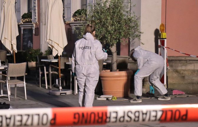 Der Tatort eines nächtlichen Polizeieinsatzes ist mit Flatterband abgesperrt, dahinter Beamte der Spurensicherung im Einsatz.<span class='image-autor'>Foto: Priebe/pr-video/dpa</span>