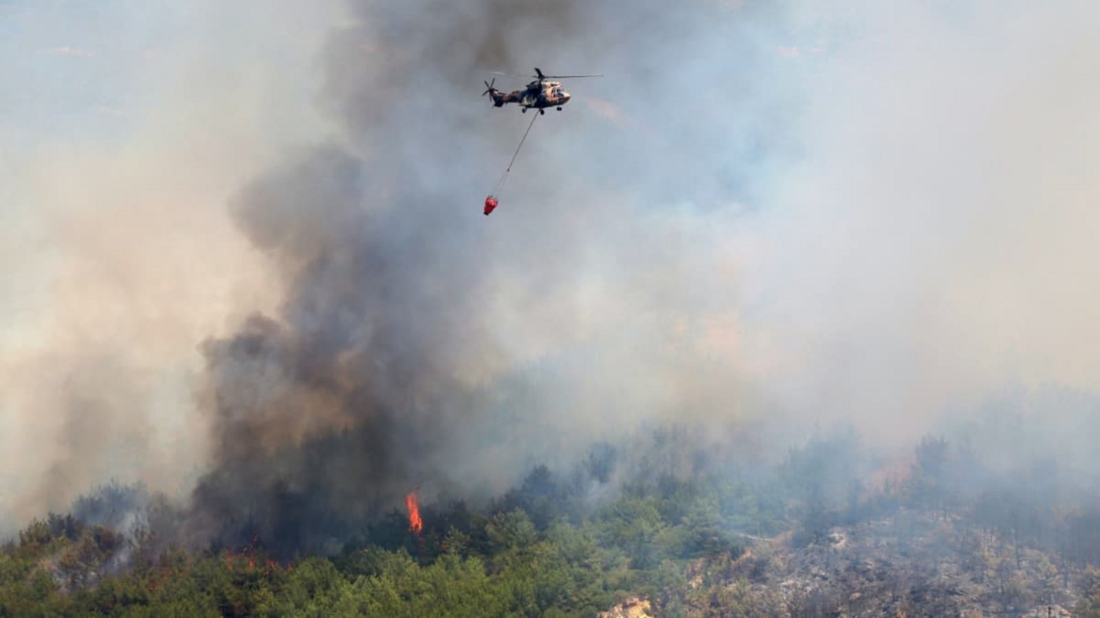 Ein Hubschrauber lässt Wasser ab, um ein Feuer in der Nähe von Izmir zu löschen. Einsatzkräfte in der Türkei kämpfen in mehreren Provinzen gegen Brände, die sich bei starken Winden ausbreiten (Archivfoto).Cengiz Malgir/DIA Photo via AP/dpa Ein Hubschrauber lässt Wasser ab, um ein Feuer in der Nähe von Izmir zu löschen. Einsatzkräfte in der Türkei kämpfen in mehreren Provinzen gegen Brände, die sich bei starken Winden ausbreiten (Archivfoto).Cengiz Malgir/DIA Photo via AP/dpa