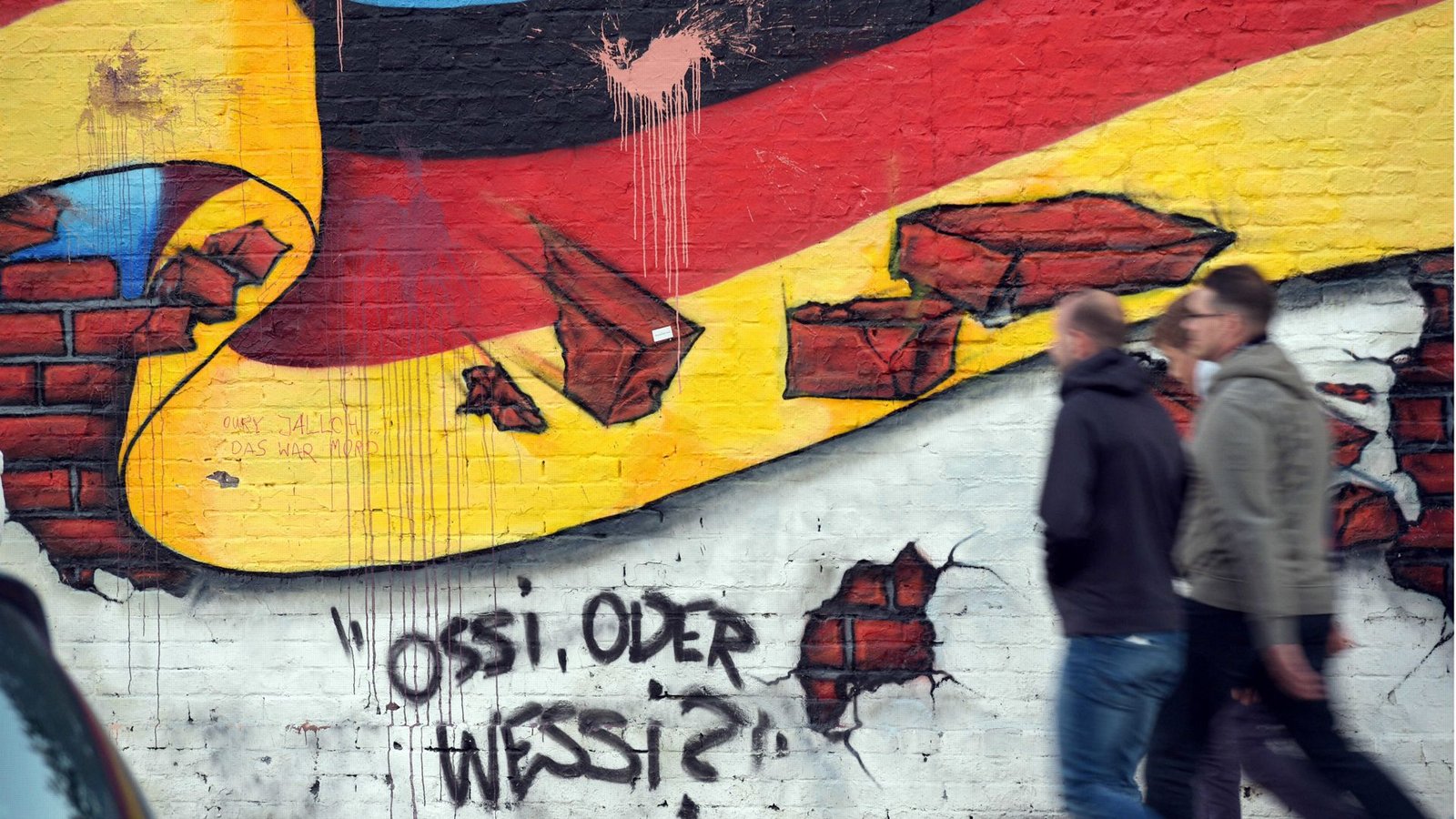 Graffito in Berlin: Auch 35 Jahre nach der Wende wird über die Ost und West diskutiert.Foto: dpa/Rainer Jensen