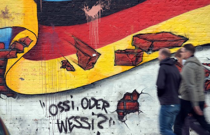 Graffito in Berlin: Auch 35 Jahre nach der Wende wird über die Ost und West diskutiert.<span class='image-autor'>Foto: dpa/Rainer Jensen</span>