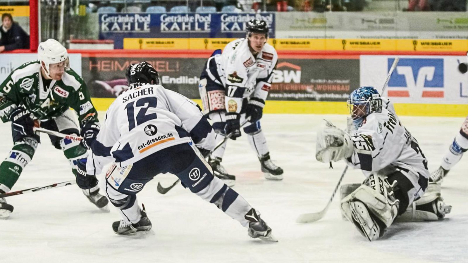Rene Schoofs (links) hämmert die Scheibe an Mirko Sacher, Harrison Reed und Torwart Brett Jaeger vorbei und trifft gegen die Dresdner Eislöwen zum vorentscheidenden 5:3. Foto: Simecek