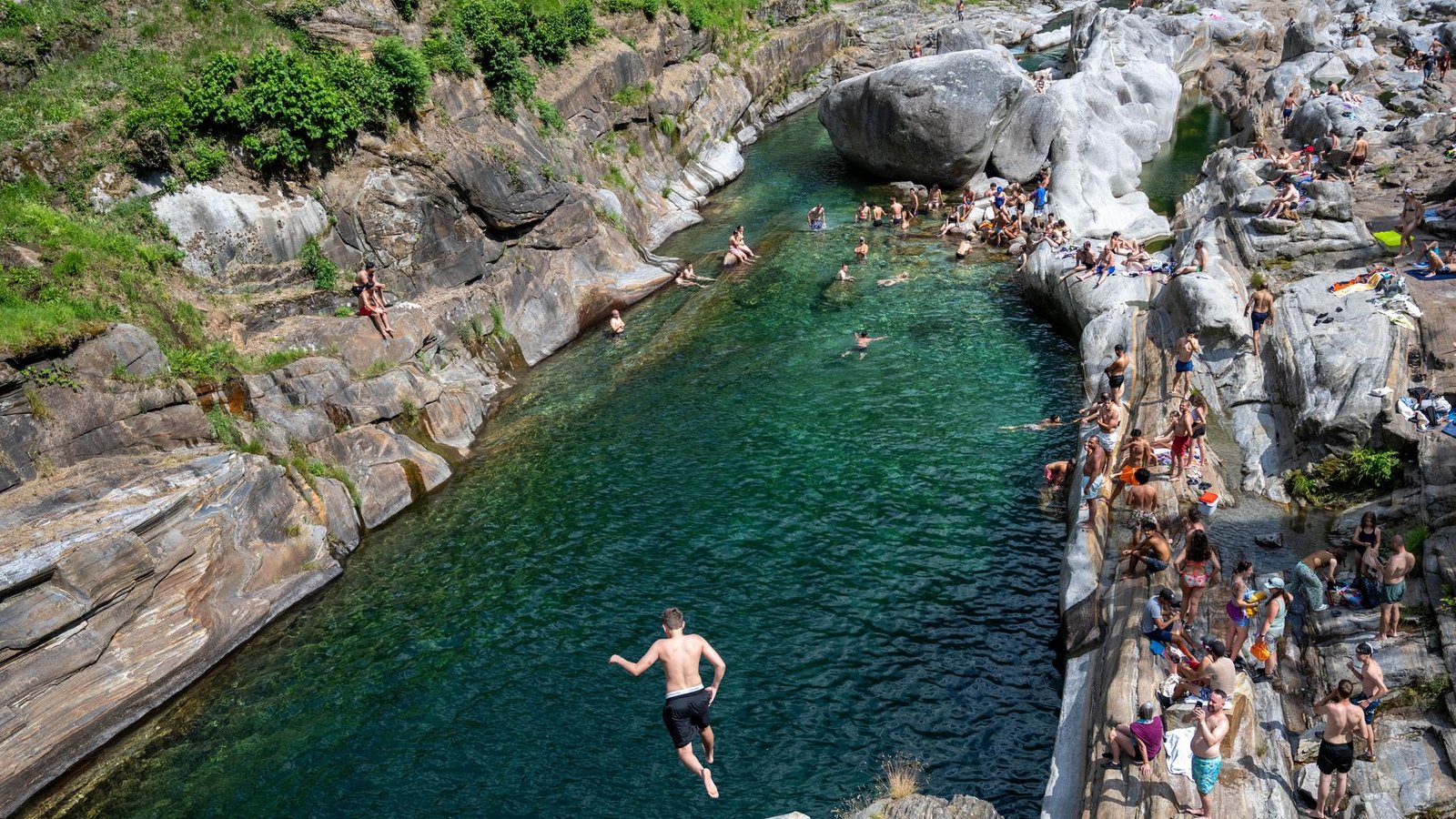 Menschen suchen Abkühlung im Wasser des Flusses Verzasca in der Schweiz.Foto: Samuel Golay/KEYSTONE/dpa Menschen suchen Abkühlung im Wasser des Flusses Verzasca in der Schweiz.Foto: Samuel Golay/KEYSTONE/dpa