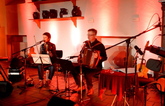 Zweimal hatte die Veranstaltung wegen Corona verschoben werden müssen. Beim dritten Anlauf am Freitag klappte es: Die Rasslerbande lud in der historischen Kelter in Mühlacker zur musikalischen Geschichtsstunde. Thema: Die als „Rassler“ bekannten Arbeiter der Pforzheimer Schmuckindustrie. „Rassler Bauer Goldschmied“ war die musikalisch-literarische Spurensuche von Sven Puchelt, Roland Bliesener, Christian Roch und Christina Sogl überschrieben, die der Pforzheimer Folkclub Prisma anlässlich des Pforzheimer Schmuckjubiläums „250 Jahre Goldstadt“ im Jahre 2017 aus gutem Grund entwickelt hatte. Als sich in Pforzheim die Schmuckindustrie entwickelte, war das auch die Geburtsstunde der „Rassler“ gewesen. Im Jahr 1850 setzte der Zustrom der Landbevölkerung ein. Um 1900 seien, wie am Abend mitgeteilt wurde, rund 24 000 Menschen in 900 Fabriken beschäftigt gewesen. Die Hälfte von ihnen waren „Rassler“. Diese „Rassler“ waren Bauern aus den umliegenden Dörfern, die jeden Morgen zur Arbeit in die Stadt wanderten. Ihren Namen bekamen sie vom Klappern der mit Eisen beschlagenen Schuhe auf dem Kopfsteinpflaster. Oder war es etwa das Klappern der Kannen, in denen sie ihr Essen mitbrachten? Oder gar die Verballhornung des Begriffs Raser? Diese Frage blieb am Freitagabend zwar unbeantwortet, auf ganz viele andere aber gab das Quartett singend und sprechend Auskunft. Das Quartett präsentierte eine gelungene Mischung aus Texten und Liedern. Da keine traditionellen Melodien aus Pforzheim und den umliegenden Gemeinden überliefert sind, hatten die Musiker historische baden-württembergische Tänze und Volkslieder ausgesucht. Letztere habe man etwas moderner arrangiert, so Christian Roch, Vorsitzender des Vereins Folkclub Prisma. Unter anderem hatte man das Gedicht „O Schwarwald, o Heimat“ von Ludwig Auerbach neu vertont. Roch wies zudem darauf hin, dass die „Rassler“ nicht nur aus der direkten Umgebung Pforzheims kamen. Auch aus dem Raum Mühlacker sei man zur Arbeit nach Pforzheim gegangen – allerdings nicht zu Fuß sondern nach dem Bau der Eisenbahnlinie mit der Bahn. Kurzweilig und äußerst informativ gaben er und die übrige Rasslerbande Einblicke in die Lebensart der Goldschmiedsbauern, die ihren Lebensunterhalt in der Schmuckindustrie, aber auch in der Landwirtschaft verdienten. Gespartes Geld floss in die eigene Scholle, so Puchelt. <span class='image-autor'>Foto: Stahlfeld</span>