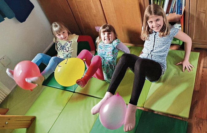 Füße und Luftballons in die Höhe! Familie Schwartz – von links Maira, Hanna und Liah – nutzt die Zeit ohne Wettkampfgymnastik für gezielte Übungen daheim. Fotos: privat (3), Rücker