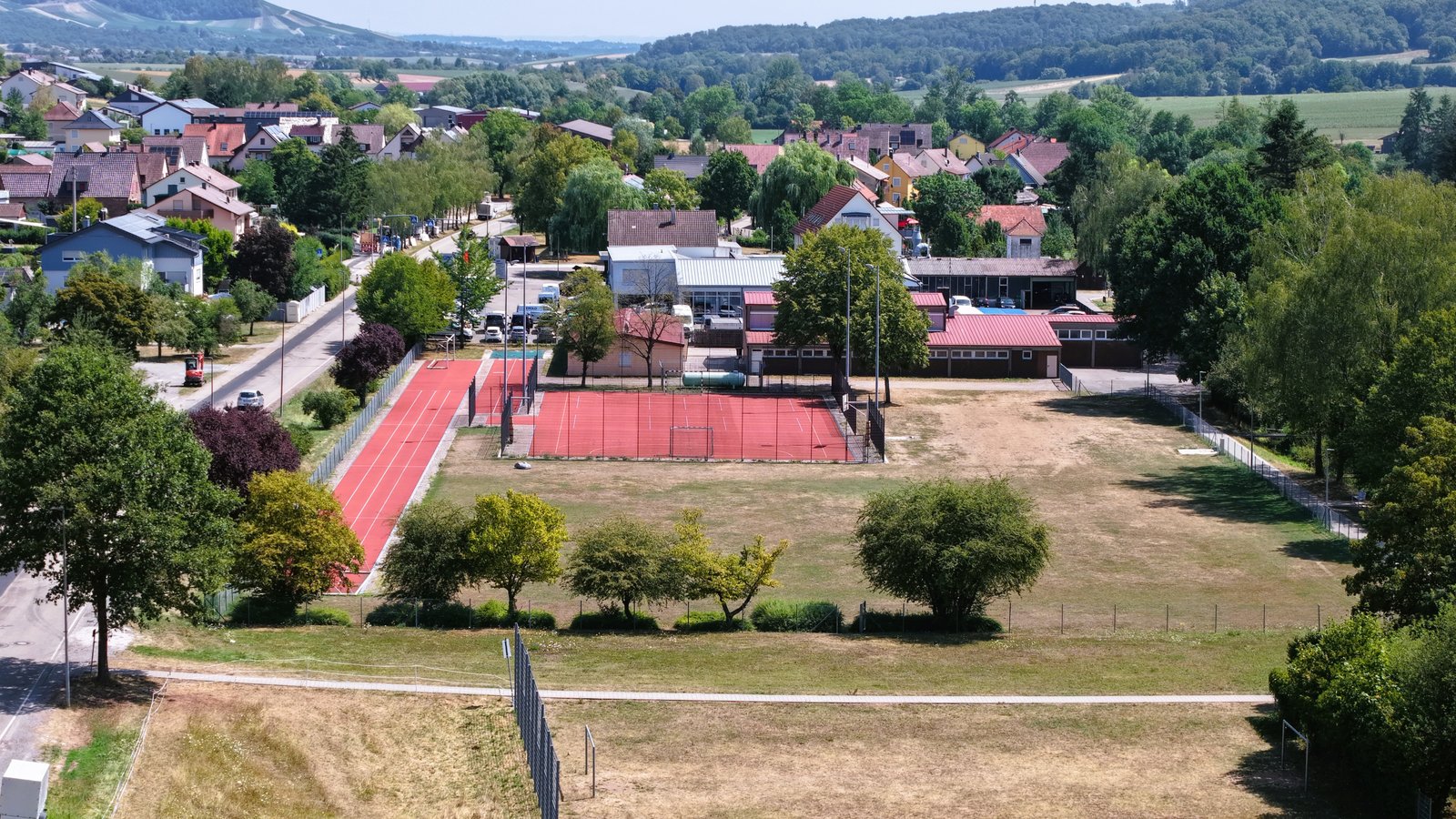 Der bisherige Bolzplatz vor dem Weg soll zur Pumptrackanlage werden. Dahinter schließen sich die übrigen Sportstätten an. Foto: Küppers Der bisherige Bolzplatz vor dem Weg soll zur Pumptrackanlage werden. Dahinter schließen sich die übrigen Sportstätten an. Foto: Küppers