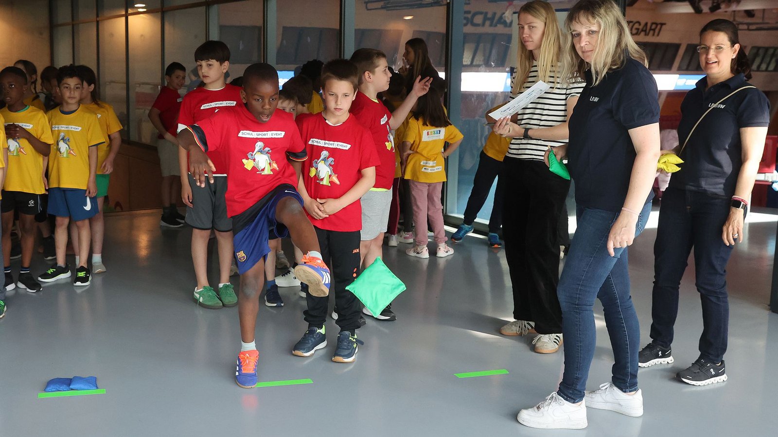 Bei der Affen-Station beweisen die Schüler ihre Geschicklichkeit. Mit dem Fuß soll das Sandsäckchen in den Reifen gekickt werden.Foto: Baumann/Hansi Britsch