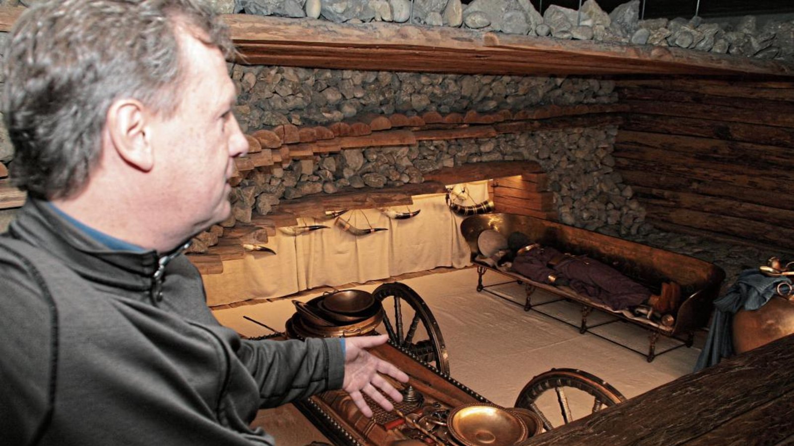 Joachim Fleischer führt in der Grabkammer des Keltenmuseums die Lichtinstallation vor.  Foto: Arning