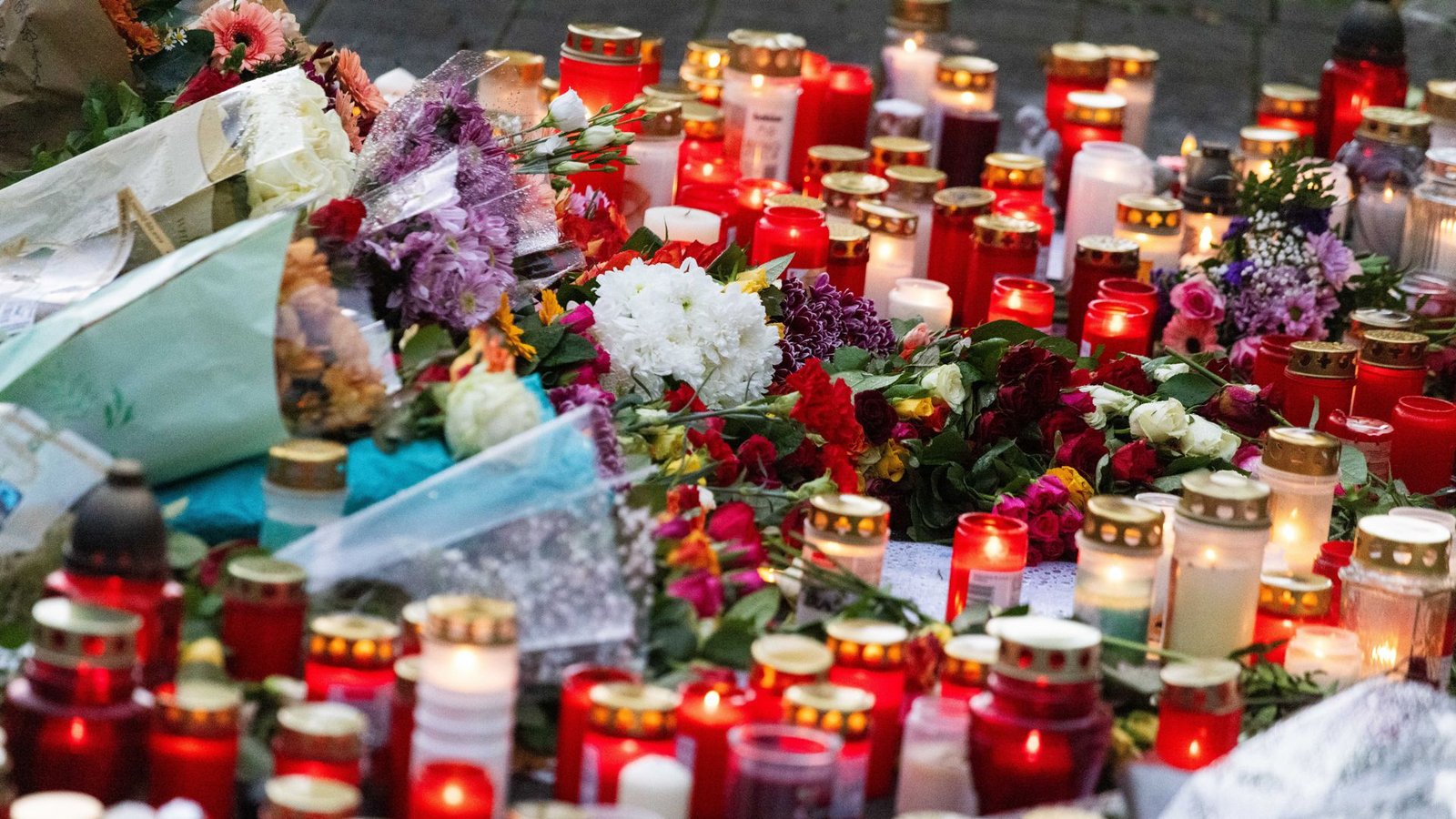 200 Trauernde stehen während einer stillen Gedenkveranstaltung rund um Blumen und Kerzen, die vor einer Schule liegen.Foto: Philipp von Ditfurth/dpa/Philipp von Ditfurth 200 Trauernde stehen während einer stillen Gedenkveranstaltung rund um Blumen und Kerzen, die vor einer Schule liegen.Foto: Philipp von Ditfurth/dpa/Philipp von Ditfurth