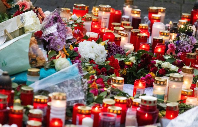 200 Trauernde  stehen während einer stillen Gedenkveranstaltung rund um Blumen und Kerzen, die vor einer Schule liegen.<span class='image-autor'>Foto: Philipp von Ditfurth/dpa/Philipp von Ditfurth</span>