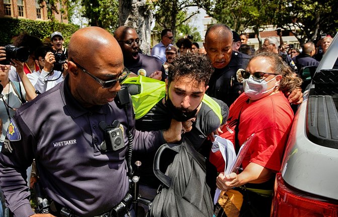 Ein Demonstrant der University of Southern California wird während einer pro-palästinensischen Besetzung des Alumni-Parks in Los Angeles von Beamten des USC Department of Public Safety festgehalten.<span class='image-autor'>Foto: Richard Vogel/AP/dpa</span>