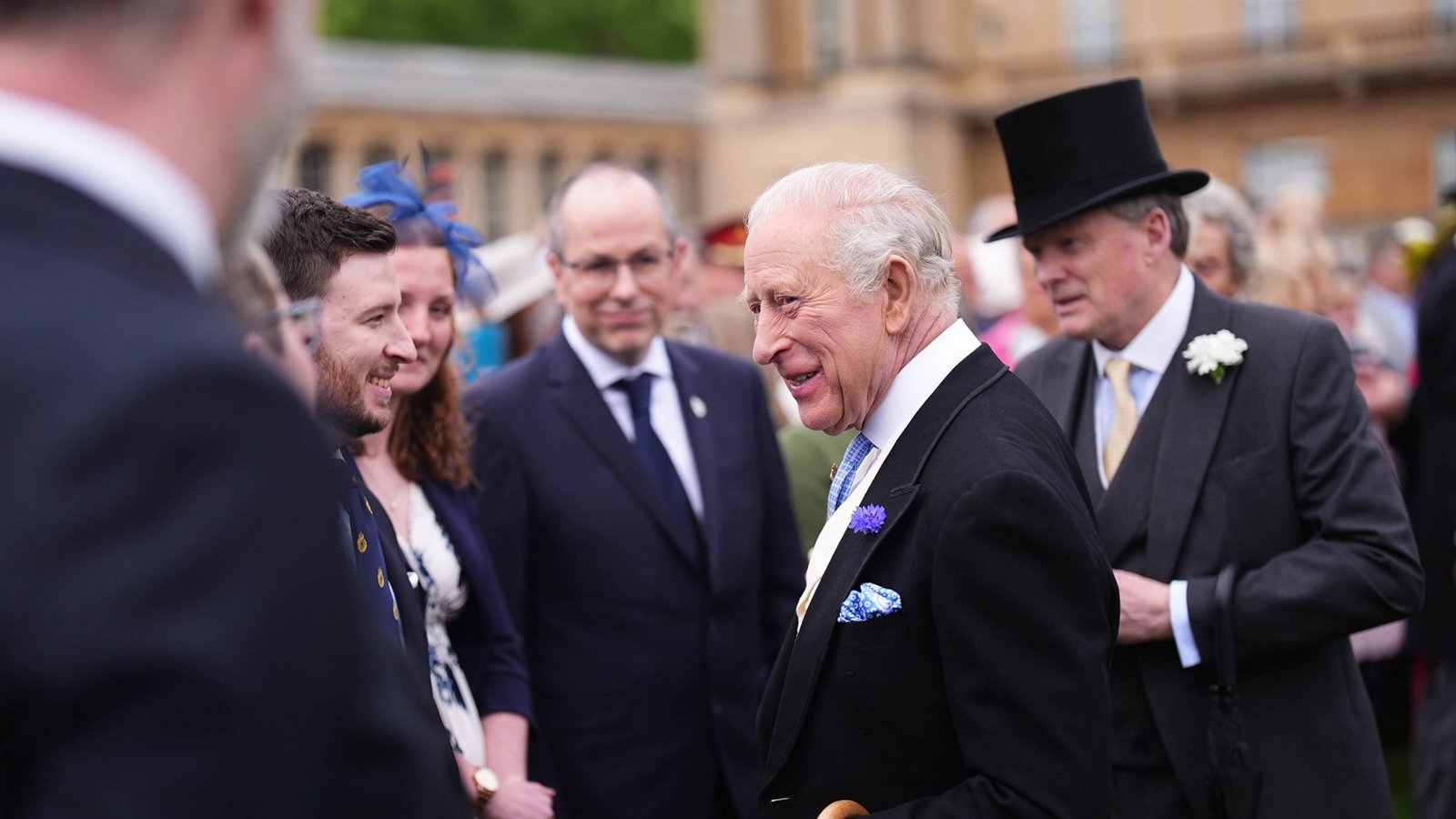 Der britische König Charles III. (M.) unterhält sich mit Gästen während der jährlichen Gartenparty im Buckingham Palace.Foto: picture alliance/dpa/PA Wire | Aaron Chown