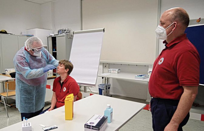 Michael Storz (links), Isabelle Bender und Maik Olpp demonstrieren die richtige Vorgehensweise beim Schnelltest. Bevor der Test durchgeführt werden kann, muss die Pufferlösung aufgesetzt werden, mit der später das Zellmaterial reagiert. Fotos: Friedrich