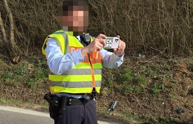 Das Handy des Polizisten hat einen Aufkleber, auf dem deutlich lesbar die Buchstaben „FCKGRN“ stehen.<span class='image-autor'>Foto: Die PARTEI Heilbronn</span>