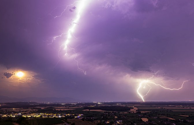 Ein Blitz geht am 28. Juni über dem Rheintal nieder während im Vordergrund der Kaiserstuhl zu sehen ist. Nach einer Woche mit Rekordhitze entladen sich zahlreiche Gewitter über dem Süden Baden-Württembergs und dem Dreiländereck.<span class='image-autor'>Foto: Philipp von Ditfurth/dpa</span>