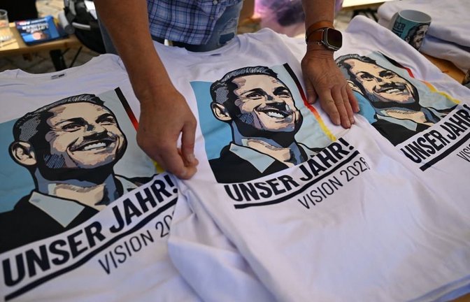 T-Shirts mit dem Portrait des AfD Spitzenkandidaten Ulrich Siegmund liegen an einem Wahlkampfstand der AfD auf dem Marktplatz in Zeitz. Die Sachsen-Anhalter wählen am 06. September einen neuen Landtag.<span class='image-autor'>Hendrik Schmidt/dpa</span>