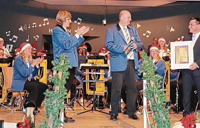 Die stellvertretende Vorsitzende des Musikvereins, Susanne Schray (li), und Uwe Zimmermann (Mitte), Bereichsleiter Kommunikation, ernannten Marco König per Urkunde zum „Meisterdirigenten“.