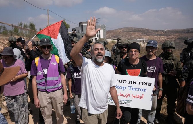 Aktivisten marschieren mit Lebensmittel- und Wasservorräten zu den Häusern von drei palästinensischen Familien, die seit sechs Tagen von israelischen Siedlern belagert werden.<span class='image-autor'>Majdi Mohammed/AP/dpa</span>