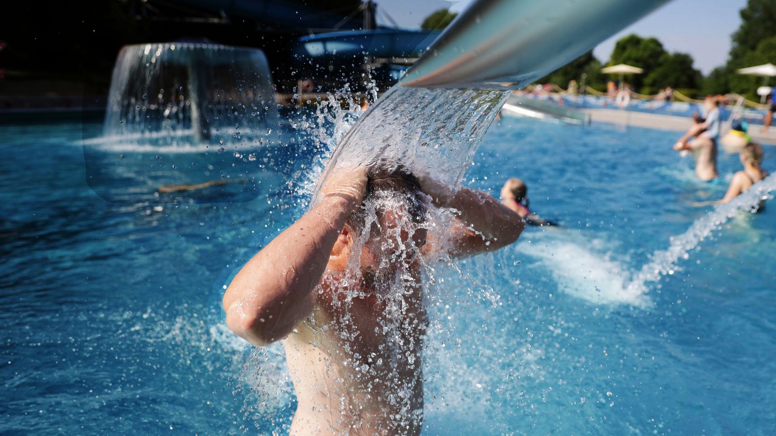 Ein Mann steht bei Temperaturen von über 30 Grad im Freibad unter einer Wasserfontäne.Foto: Thomas Warnack/dpa/Thomas Warnack Ein Mann steht bei Temperaturen von über 30 Grad im Freibad unter einer Wasserfontäne.Foto: Thomas Warnack/dpa/Thomas Warnack
