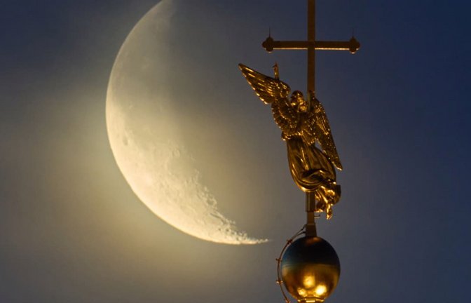 Der Mond geht hinter dem Wahrzeichen der russischen Stadt St. Petersburg – einer Wetterfahne in Form eines Engels, die auf der Spitze eines Turms der Peter-und-Paul-Kathedrale angebracht ist – aus den Wolken auf.<span class='image-autor'>Dmitri Lovetsky/AP/dpa</span>