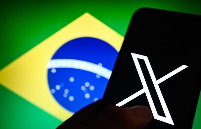 Der Kurznachrichtendienst X war in Brasilien (Flagge im Hintergrund) seit mehr als einem Monat nicht aufrufbar. (Symbolbild)<span class='image-autor'>Foto: IMAGO/SOPA Images/IMAGO/Omar Marques / SOPA Images</span>