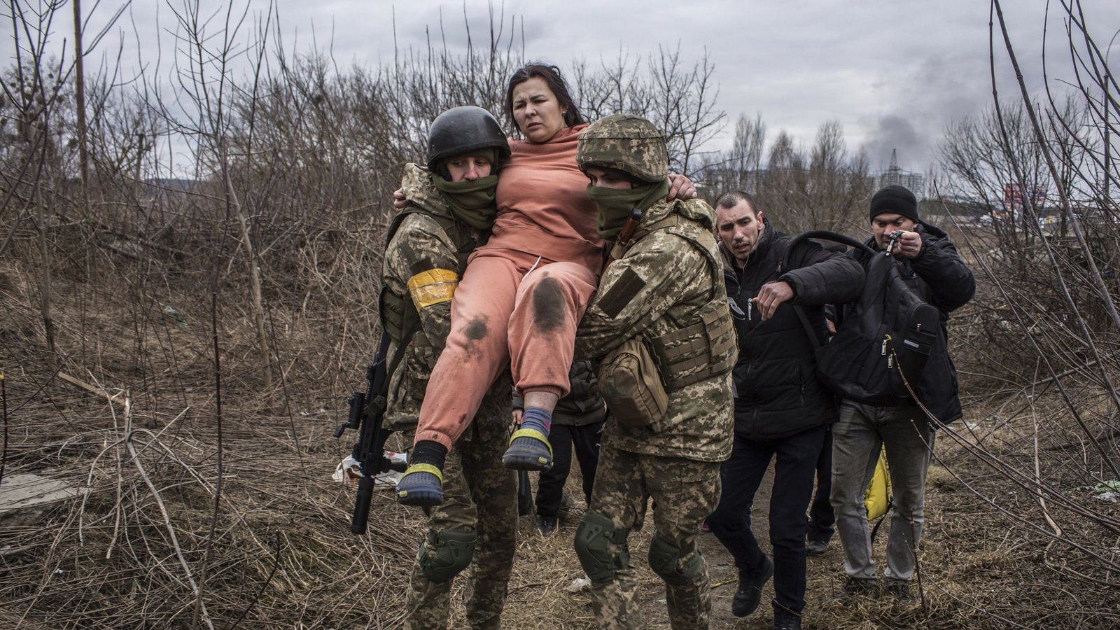 Eine Frau wird bei der Flucht aus der Stadt Irpin von ukrainischen Soldaten getragen.Foto: dpa/Oleksandr Ratushniak