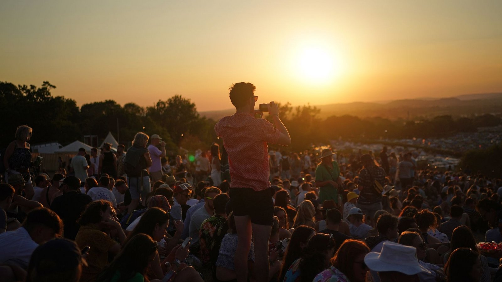 Besucher des Glastonbury Festivals in Großbritannien beobachten den Sonnenuntergang.Foto: Yui Mok/PA Wire/dpa