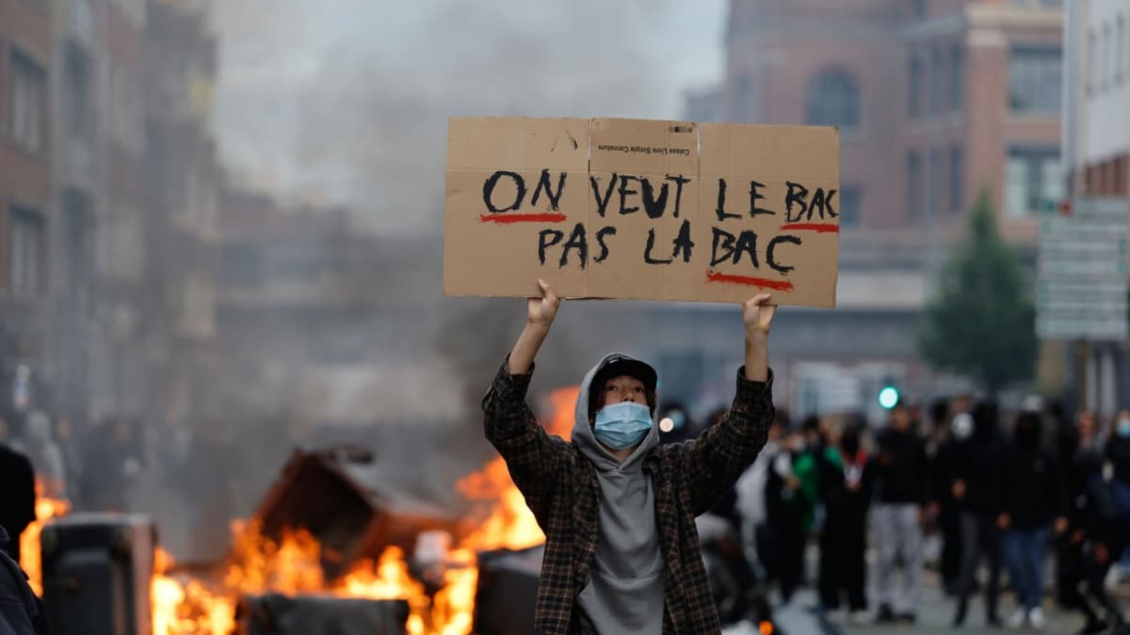 Schulproteste in Frankreich: Ein Schüler hält während einer Demonstration für mehr Mittel und mehr Personal an der Schule ein Schild mit der Aufschrift «Wir wollen das BAC (Abitur), nicht die BAC (Einheiten zur Verbrechensbekämpfung)» hoch. Seit Tagen protestieren Schülerinnen und Schüler an den Oberschulen.Jean-Francois Badias/AP/dpa