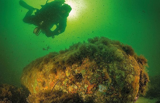 Ein Forschungstaucher untersucht eine Seemine aus dem Zweiten Weltkrieg im Munitionsversenkungsgebiet Kolberger Heide in der Kieler Außenförde.<span class='image-autor'>Foto: GEOMAR/
Christian Howe, www.h2owe.de</span>