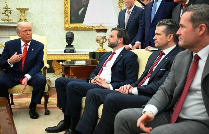 Auf einem Sofa sitzend verfolgen Sicherheitsberater Mike Waltz (v. re.) , Verteidigungsminister Pete Hegseth und Vizepräsident J.D. Vance dem US-Präsidenten Donald Trump bei einem Pressetermin im Oval Office des Weißen Hauses.<span class='image-autor'>Foto: AFP/Mandel Ngan</span>