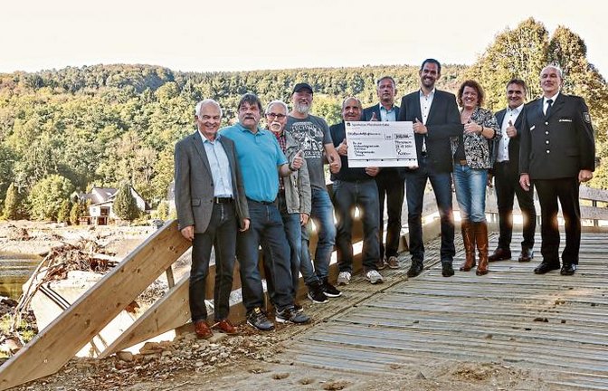 Fünf Vertreter der Verbandsgemeinde Adenau beziehungsweise der Gemeinde Insul, Königsbach-Steins Bürgermeister Heiko Genthner, Landrat Bastian Rosenau, Niefern-Öschelbronns Bürgermeisterin Birgit Förster, Bürgermeister Heiko Faber (Kieselbronn) und den stellvertretenden Kreisbrandmeister des Enzkreises, Manfred Wankmüller (von links). Die Begegnung fand an der provisorischen Brücke statt, die derzeit wertvoller Ersatz für die völlig zerstörte historische Brücke ist und die Verkehrsverbindung innerhalb des Ortes wiederherstellt. Die Brücke ist eine sogenannte Faltfestbrücke mit 40 Metern Länge, errichtet von der Bundeswehr.  Foto: Dreschers