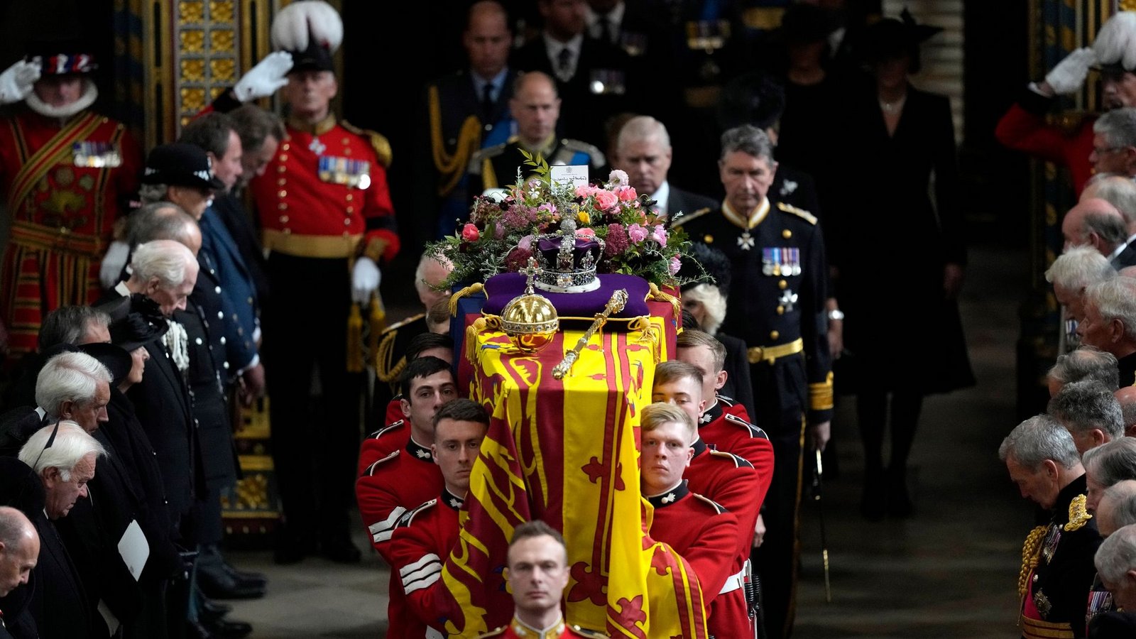 Mitglieder der königlichen Familie folgen dem Sarg von Königin Elizabeth II., der von mehreren Männern getragen wird.Foto: Frank Augstein/Pool AP/dpa