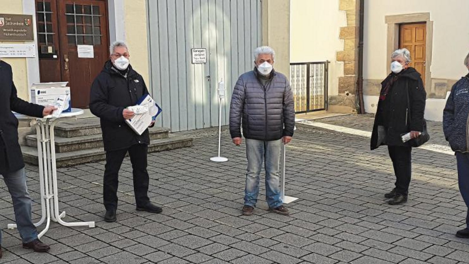 Sachsenheims Bürgermeister Holger Albrich (ganz links) verteilte mit Gemeinde- und Ortschaftsrat Hans-Günther Neumann (2.v.l.) und Ortsvorsteher Alfred Xander (ganz rechts) am Samstag vor der Hohenhaslacher Verwaltungsstelle FFP2-Masken an Senioren. Foto: Glemser Sachsenheims Bürgermeister Holger Albrich (ganz links) verteilte mit Gemeinde- und Ortschaftsrat Hans-Günther Neumann (2.v.l.) und Ortsvorsteher Alfred Xander (ganz rechts) am Samstag vor der Hohenhaslacher Verwaltungsstelle FFP2-Masken an Senioren. Foto: Glemser