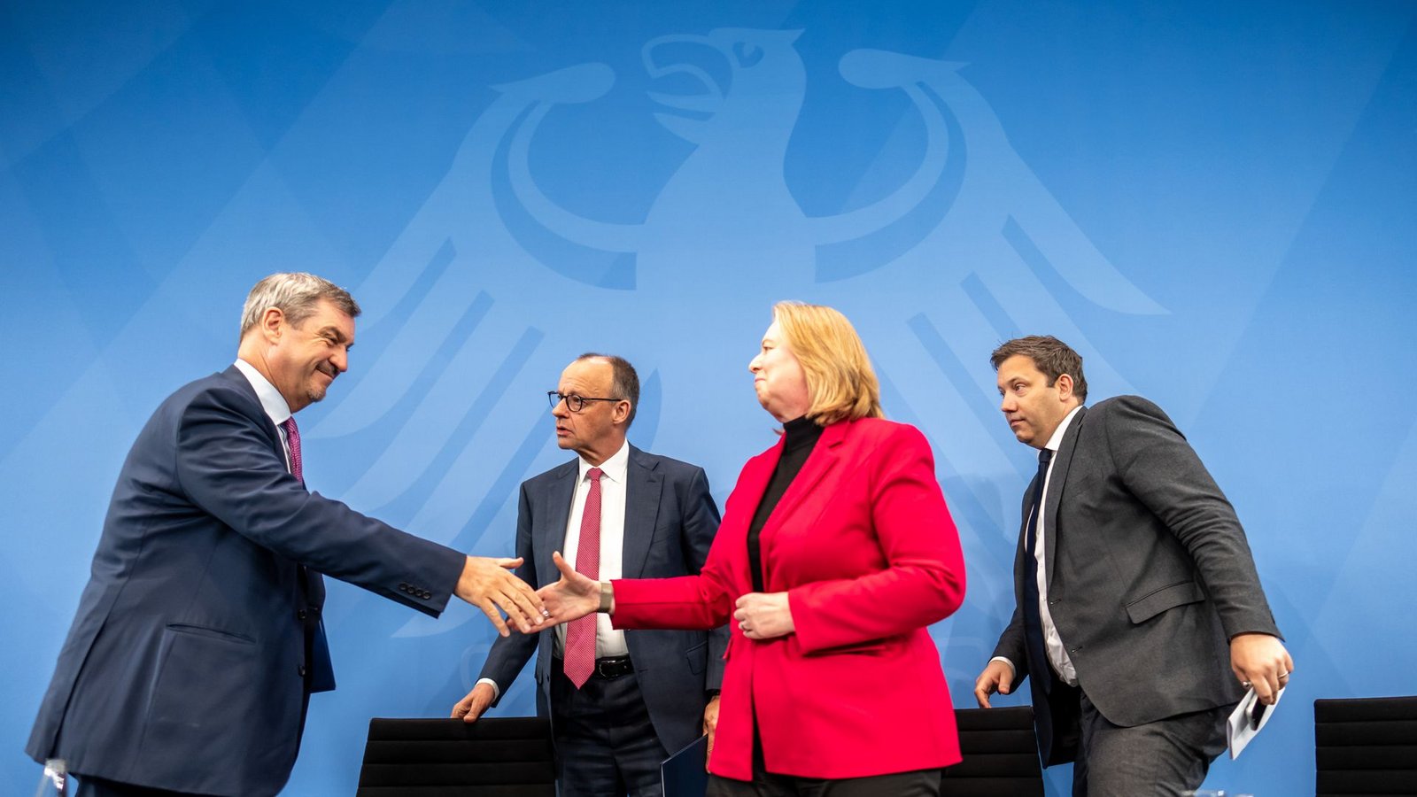Unter dem wachsamen Auge des Bundesadlers: Markus Söder (CSU, v. li. n. re.),  CSU Vorsitzender reicht Bärbel Bas (SPD), Bundesarbeitsministerin, vor Bundeskanzler Friedrich Merz (CDU, Mi.) und neben Lars Klingbeil (SPD, re.), Bundesfinanzminister, nach der Pressekonferenz nach dem Koalitonsausschuss die Hand.Foto: Michael Kappeler/dpa