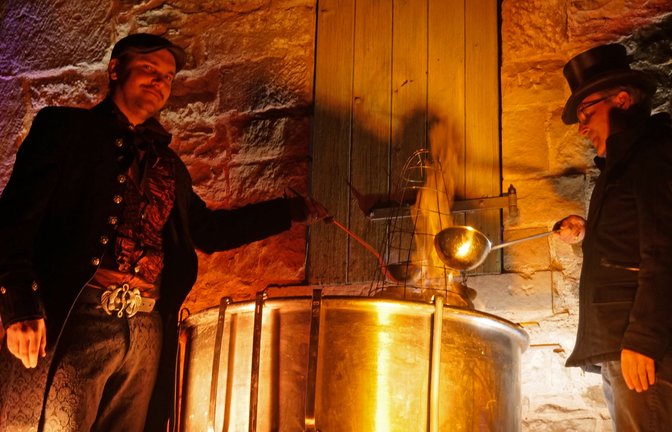 Organisator Matze Gutstein (links) und Bürgermeister Armin Pioch bereiten die Feuerzangenbowle fachkundig zu.