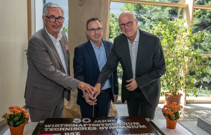 Landrat Dietmar Allgaier, Staatssekretär Andreas Deuschle (MdL) und Schulleiter Stefan Ranzinger (v.li.) schneiden die Torte zum 50. Geburtstag des Beruflichen Gymnasiums an.<span class='image-autor'>Markus Schöll</span>